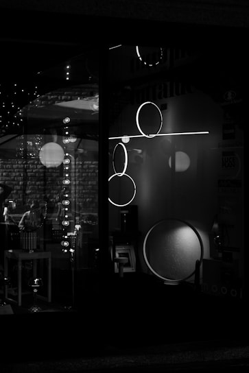 A sleek black and white photograph showcasing minimalist retail display design with perfect lighting and shadows.