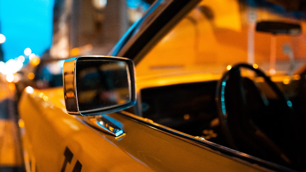 close-up photography of yellow car left side mirror