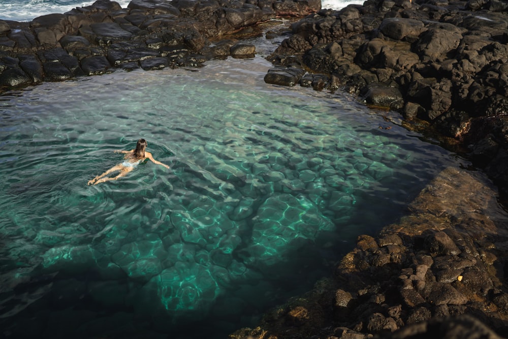 girl swimming in body of water during daytime