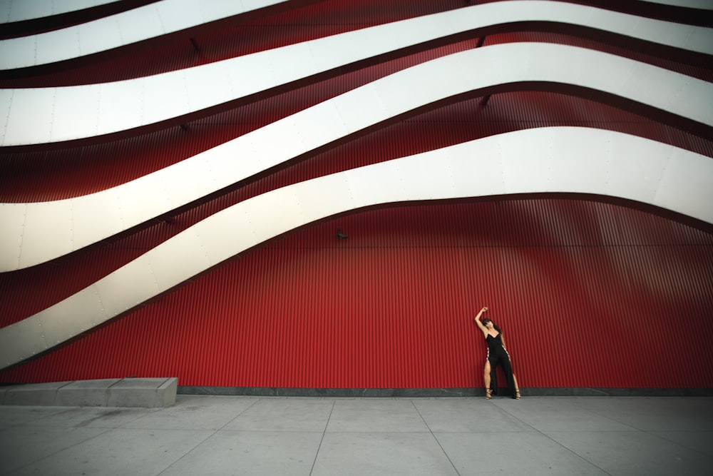 woman leaning on white and red wal