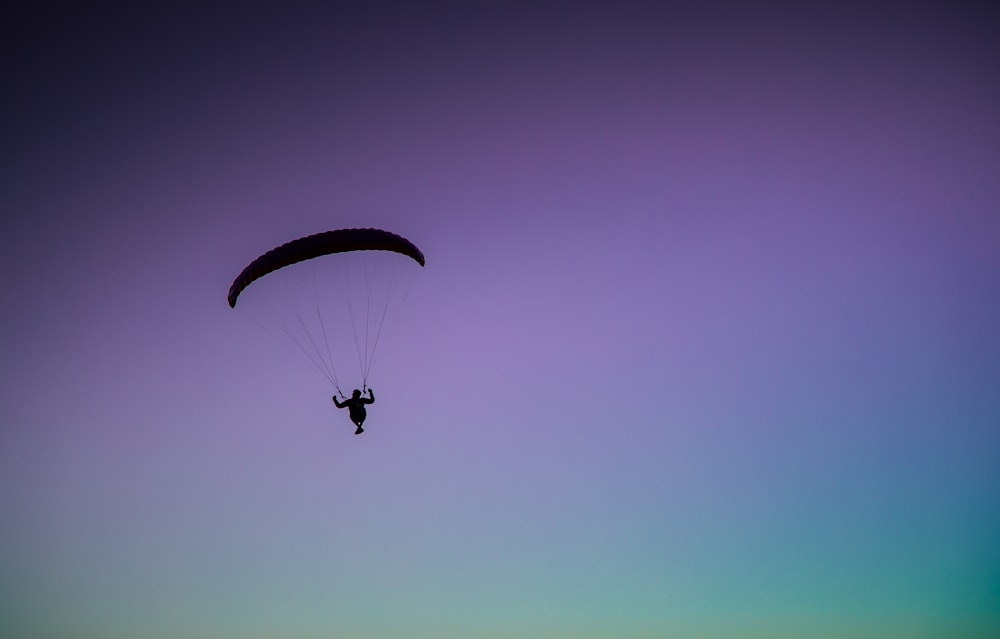 person parachuting on skies