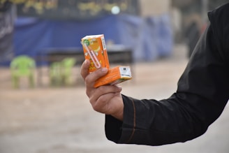 Juice cartons of mango and orange flavors stacked with eco-friendly straws nearby.