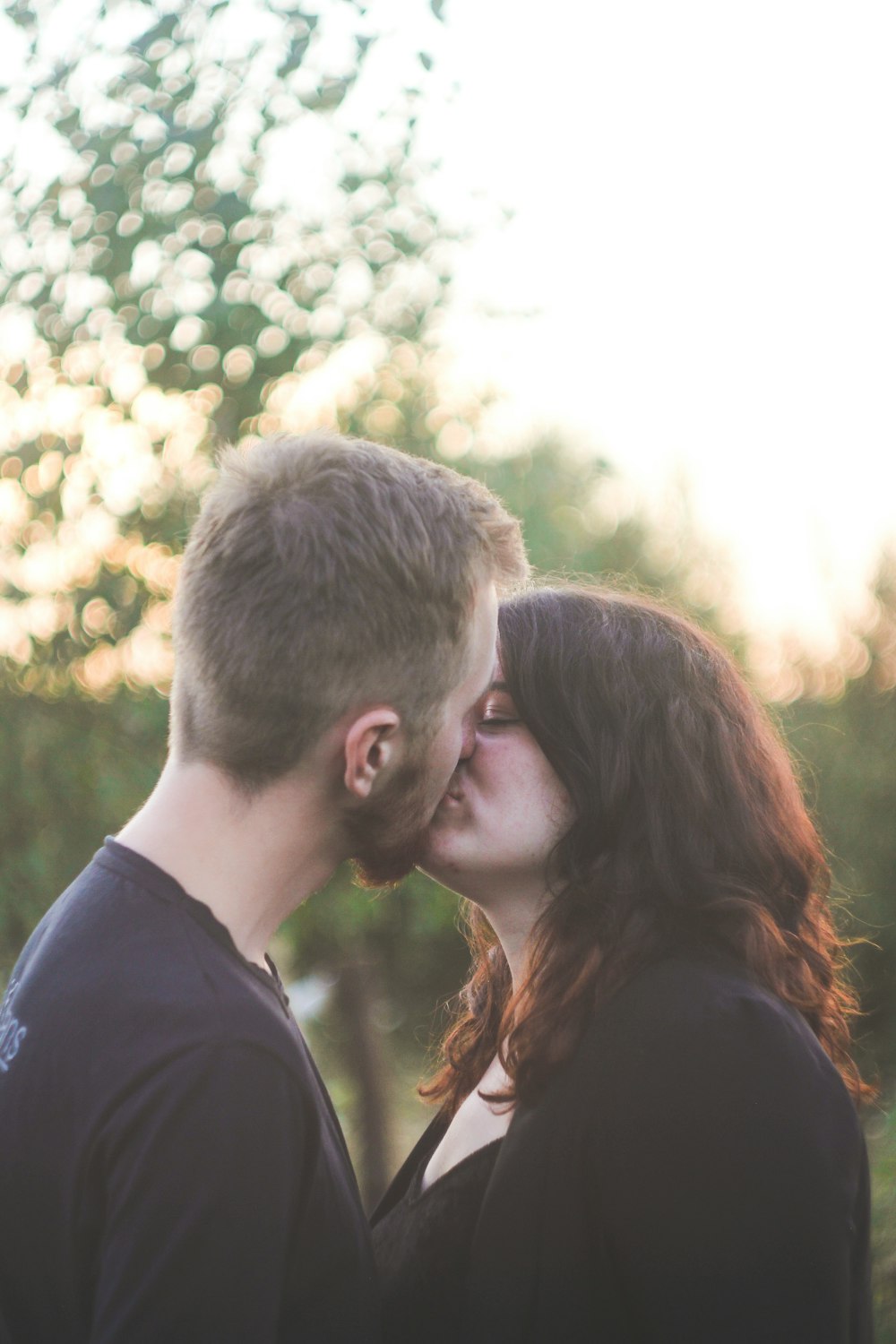 man and woman kissing during daytime