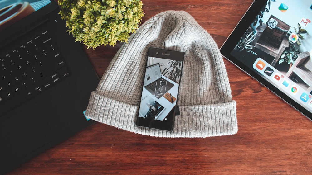 casquette en tricot gris sous smartphone noir