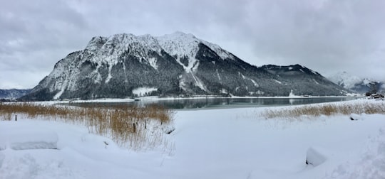 grey mountain near body of water during daytime in Achen Lake Austria