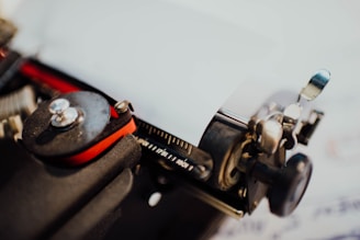 A close-up of a vintage typewriter being repaired with tools and parts nearby.