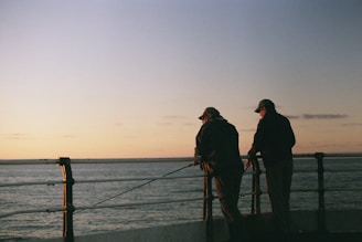 two men fishing by the railing