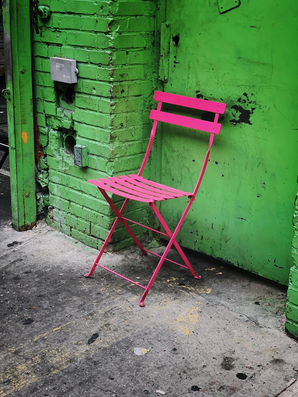 녹색 벽 근처의 빈 분홍색 팔걸이 의자
