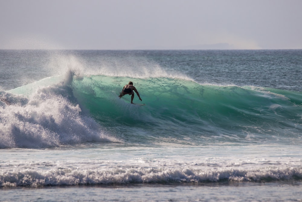 homme surfant sur les vagues de l’eau