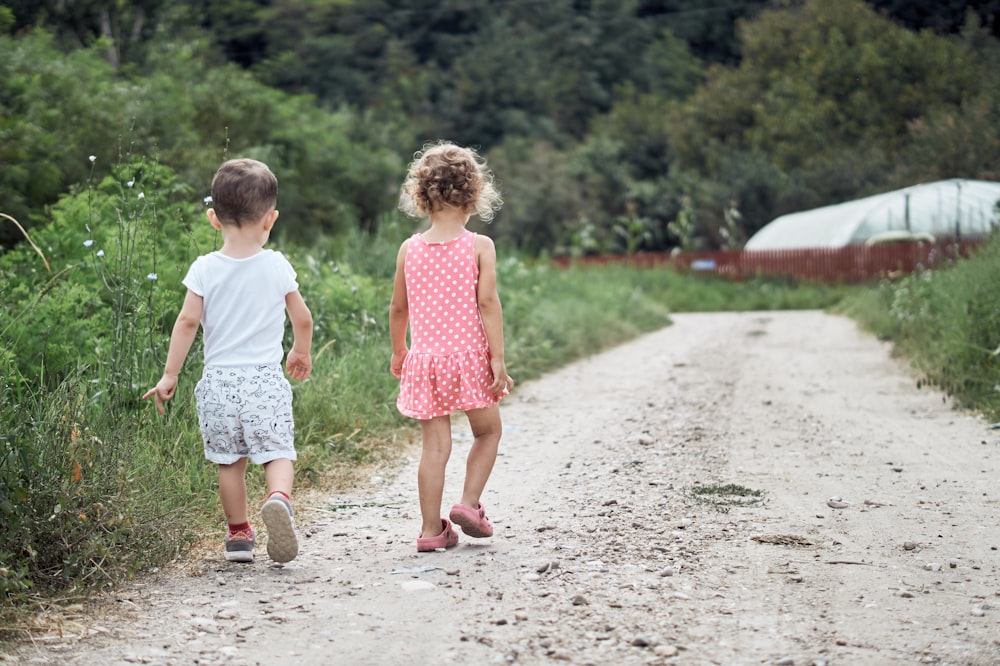 girl and boy walking on the side of the road