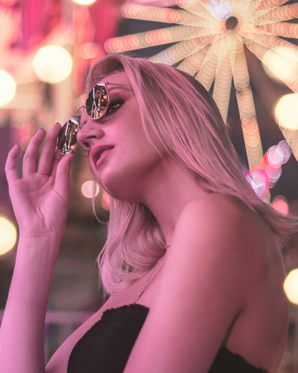 selective focus photography of woman about to take off her shades