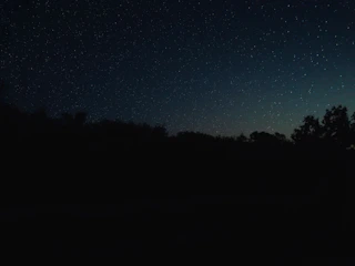A serene night sky with glowing stars twinkling over a mystical tarot card layout