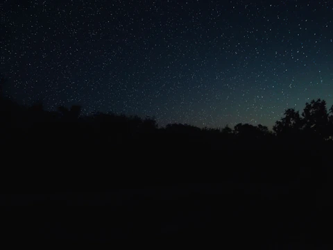 A serene night sky with glowing stars twinkling over a mystical tarot card layout