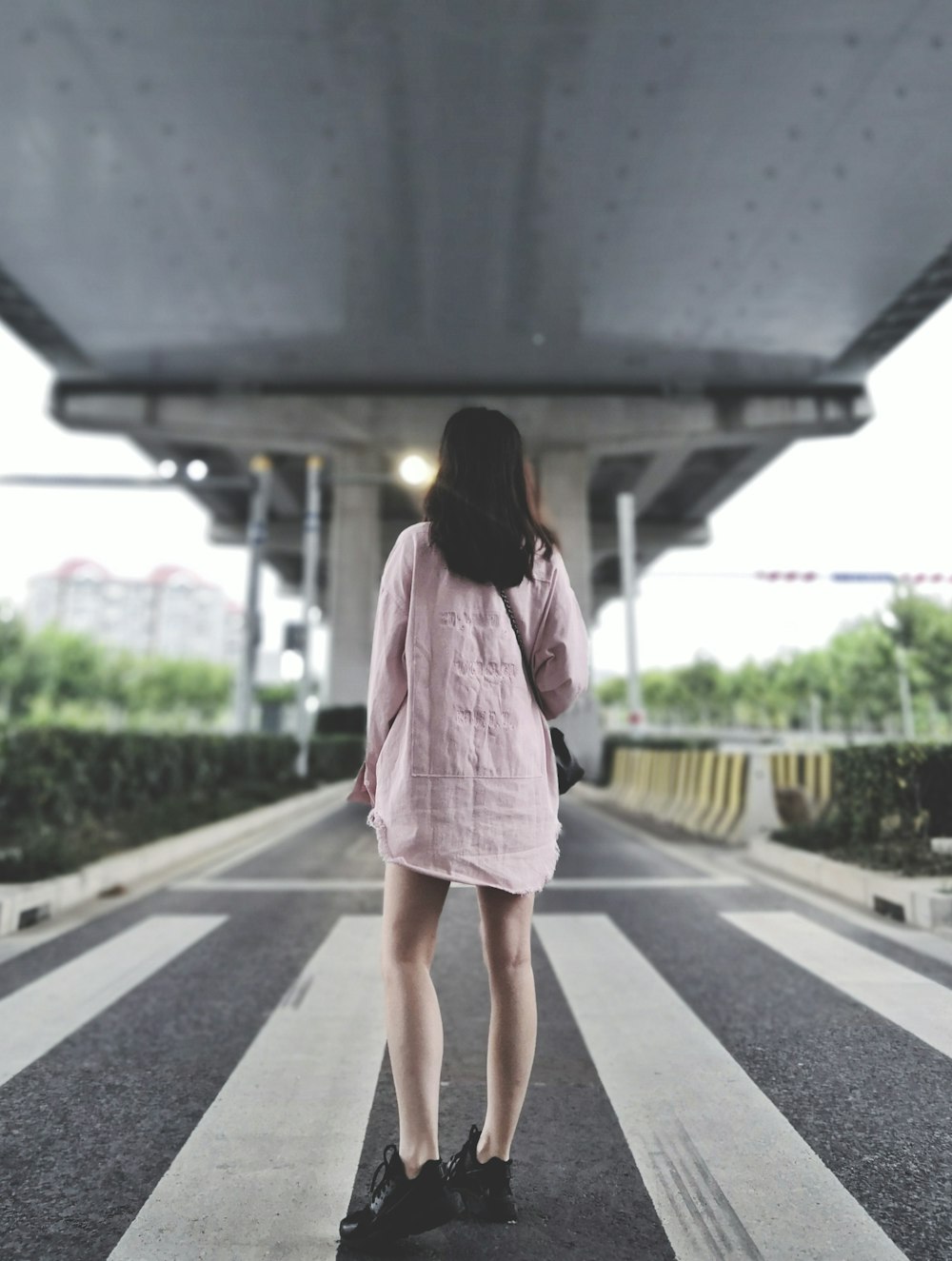 girl standing on pedestrian lane during daytime