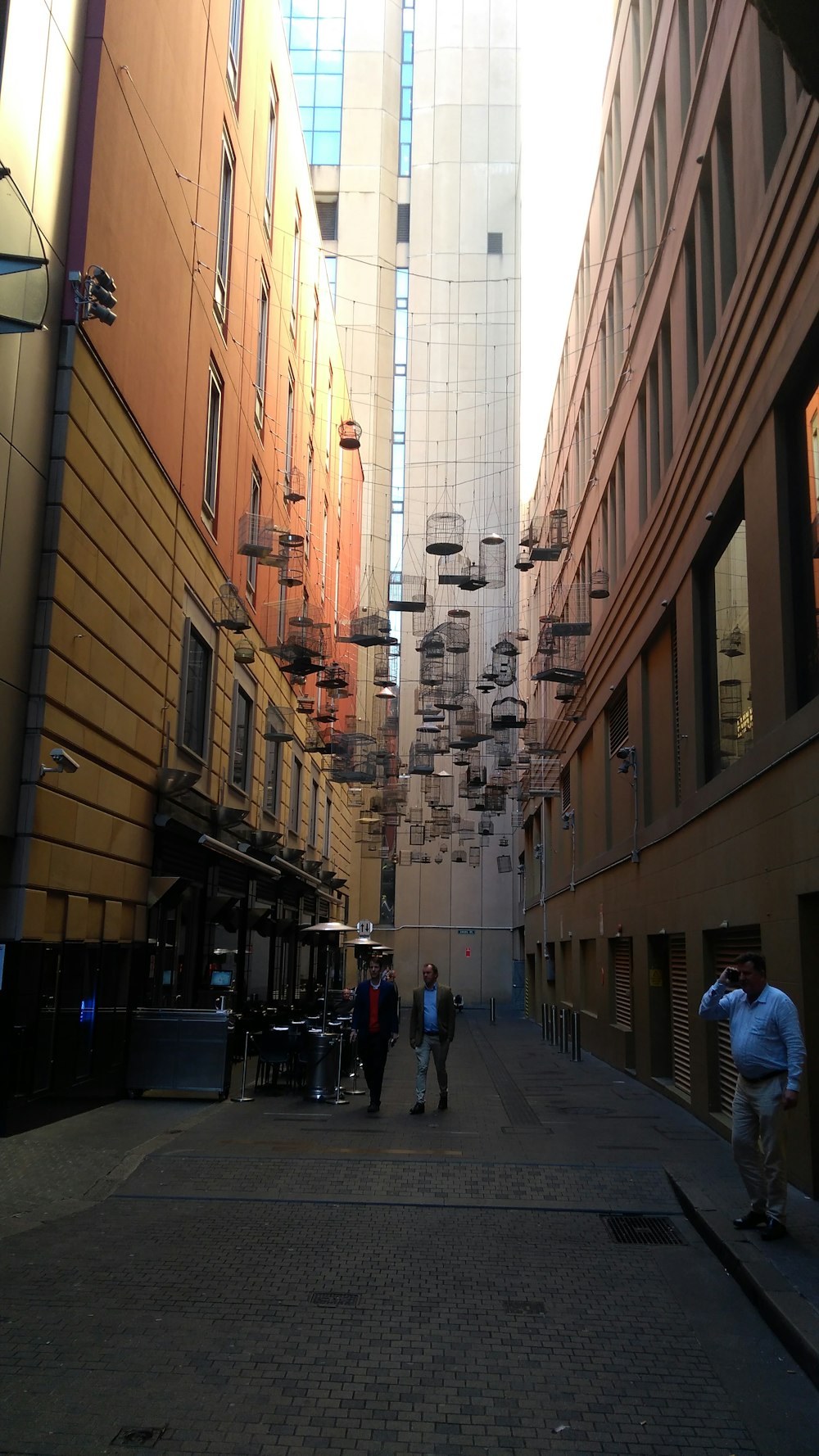 three men standing on streets between buildings