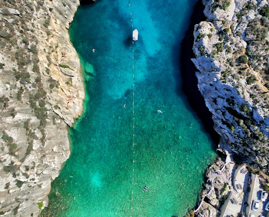 green body of water surrounded by rock formation aerial photography in Gozo Malta