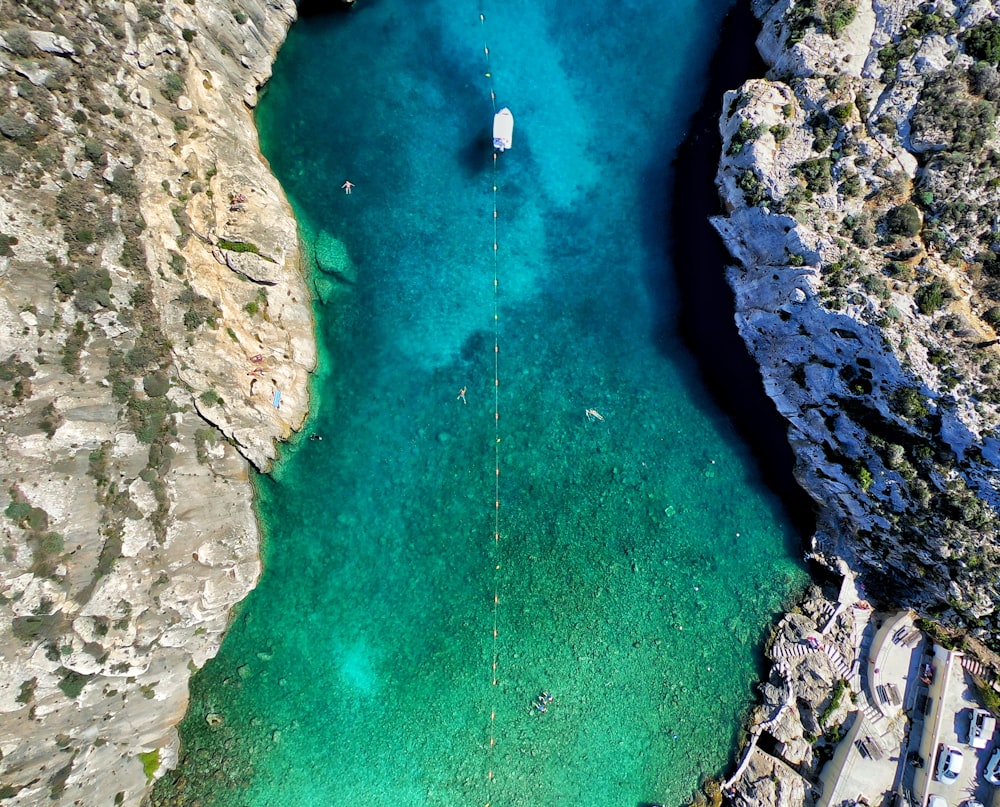 green body of water surrounded by rock formation aerial photography