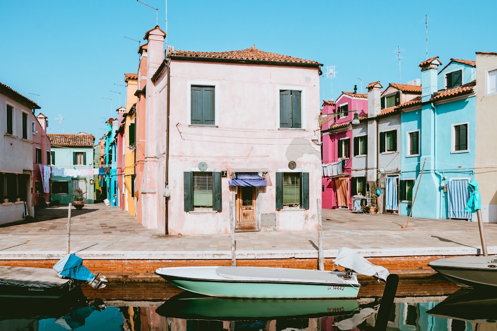 boat near dock and colorful houses under clear blue sky