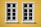 Two white-framed windows with multiple panes are set against a vibrant yellow wall. The windows have a symmetrical design and cast subtle shadows on the wall, suggesting bright daylight.