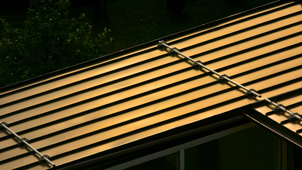 a close up of a metal roof with a tree in the background