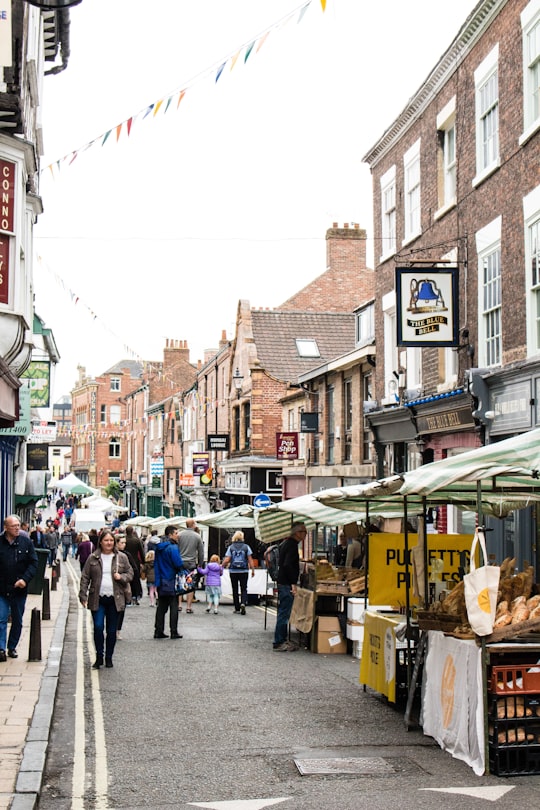 people waking on streets surrounded by buildings during daytime in York United Kingdom