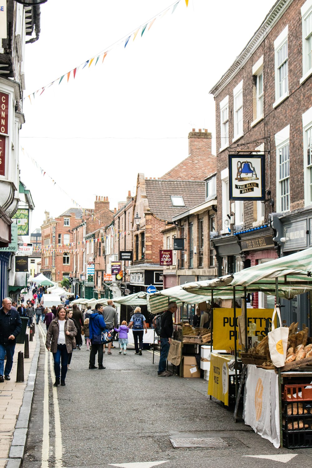 people waking on streets surrounded by buildings during daytime