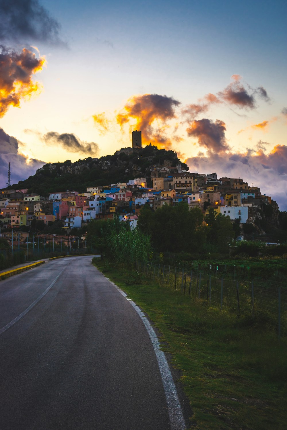 houses near mountain cliff under nimbus clouds