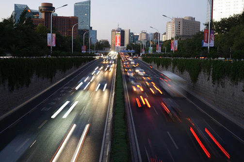 A busy urban road with fresh asphalt and modern street lighting at dusk.