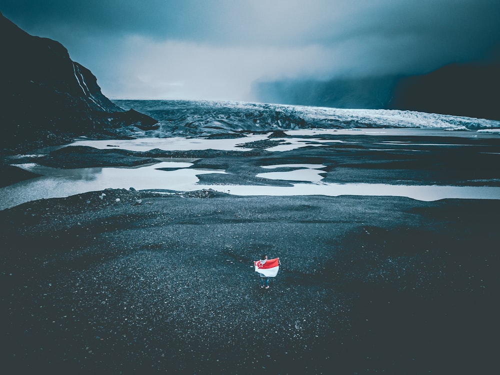 person standing in front of body of water during cloudy day