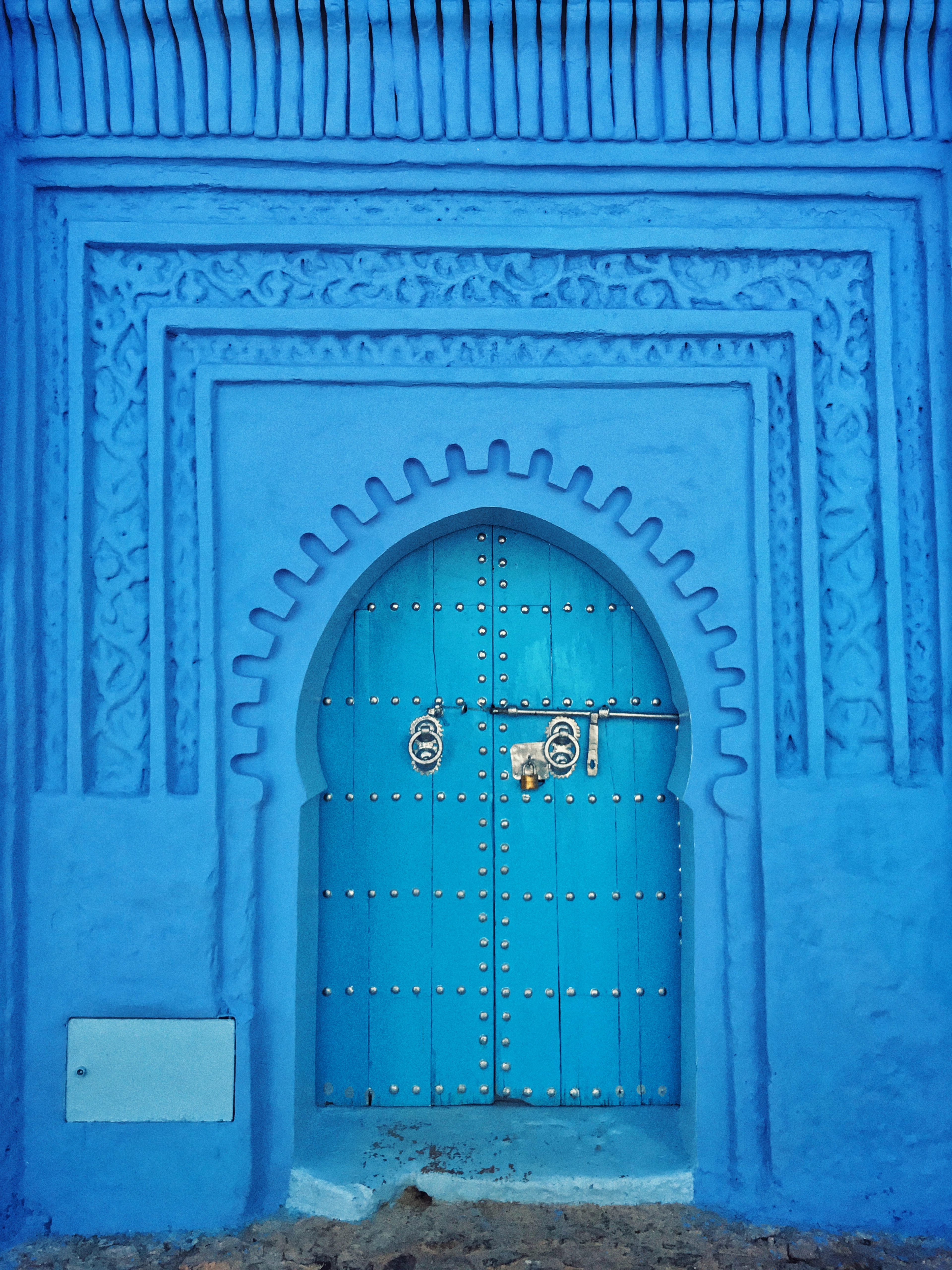 A blue-painted wall and carved doorway