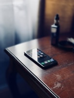 A stylish vape pen resting next to a smartphone and keys on a café table.