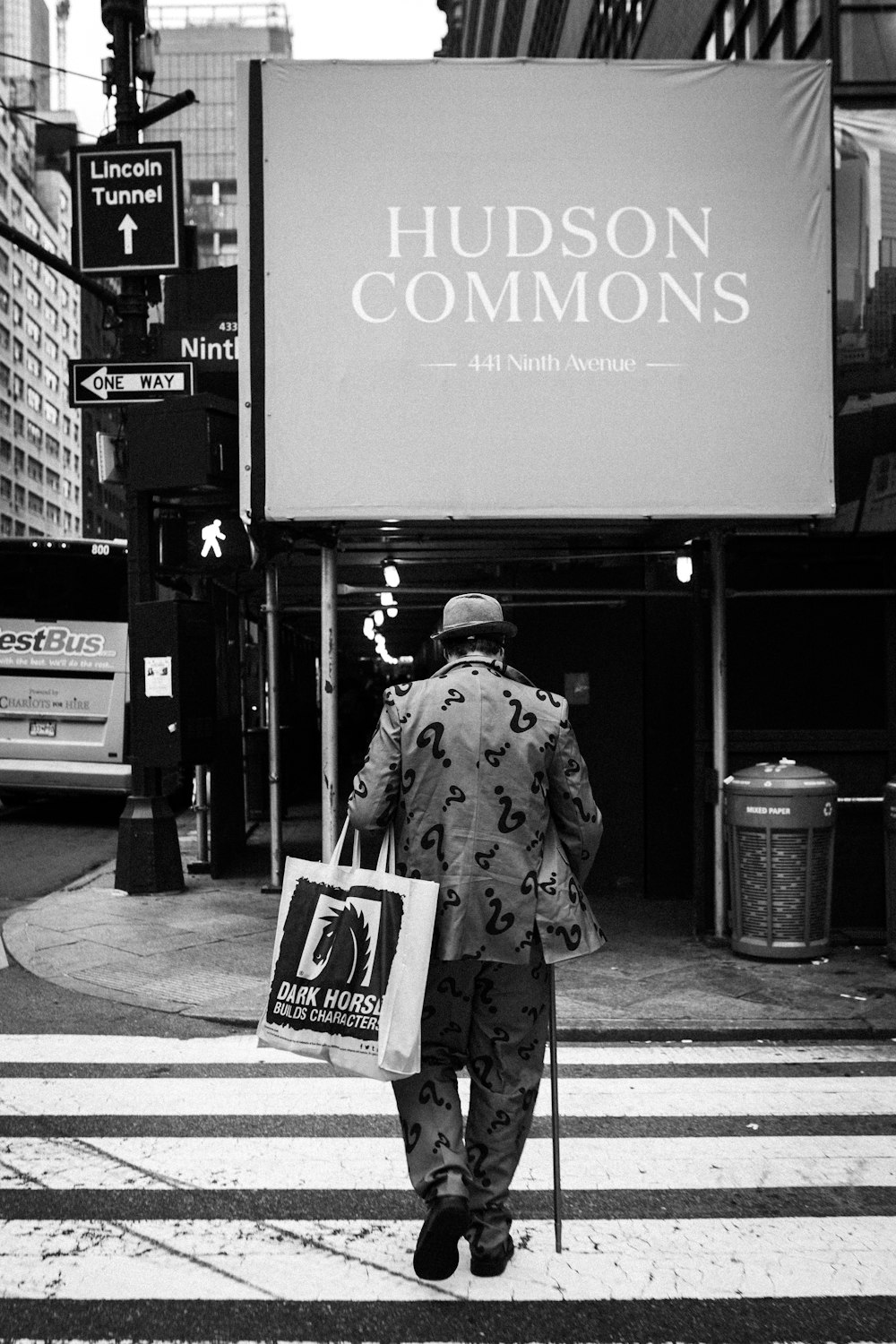 a man walking across a street holding a sign