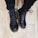 A close-up of stylish women's boots on a wooden floor.