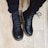 A close-up of stylish women's boots on a wooden floor.