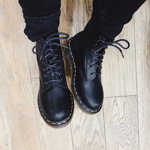 A man wearing durable work boots standing on a garage floor.