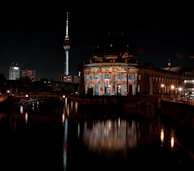 A dramatic videomapping projection illuminating a historic building at night.