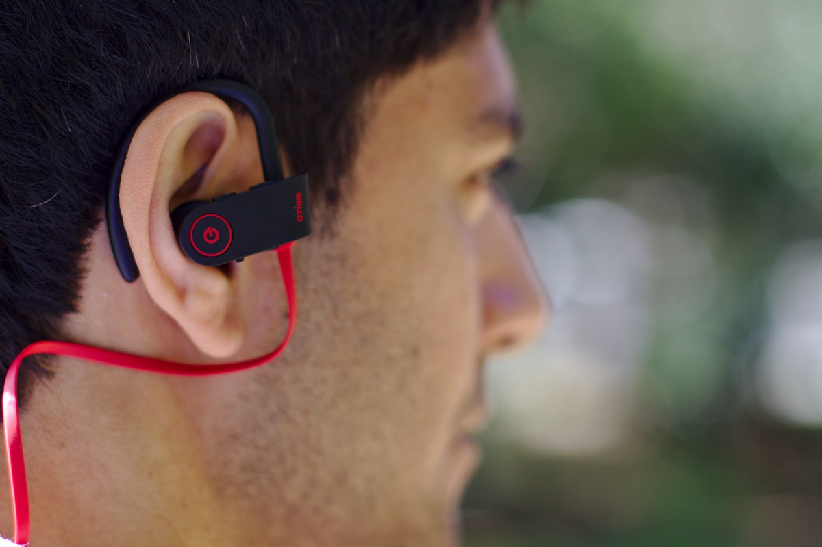 Man wearing black and red earloop earphone