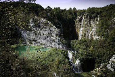 A serene view of turquoise waterfalls cascading over lush green rocks at Plitvice Lakes.