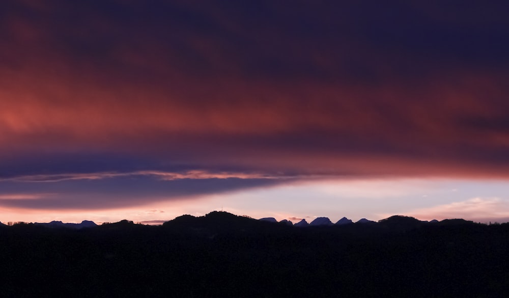 silhouette photograph of mountain ranges during golden hour