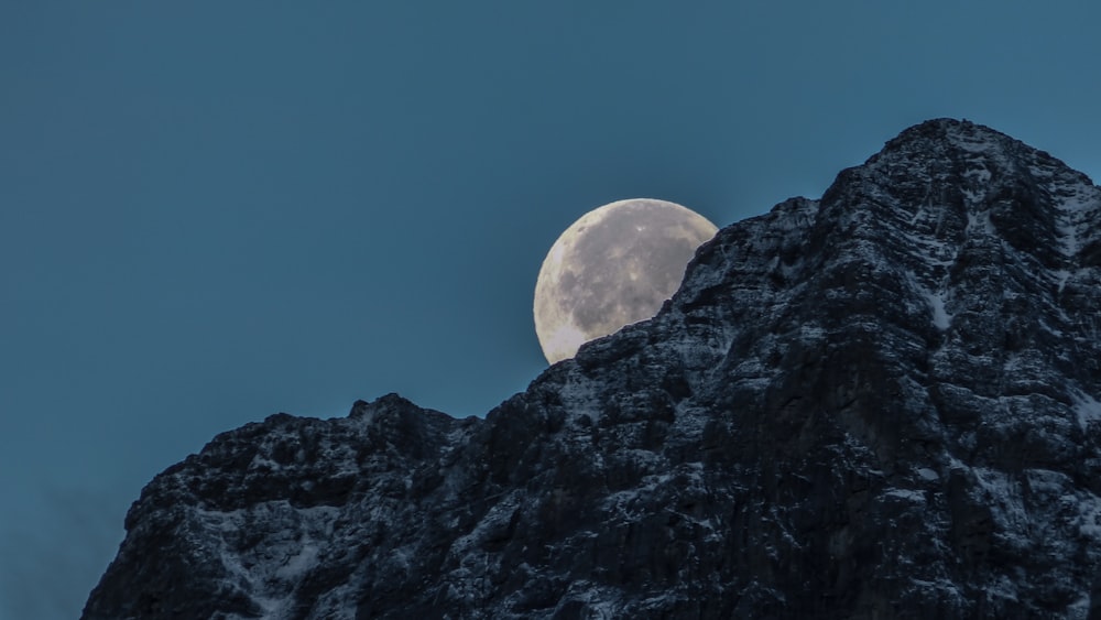 moon behind rock mountain