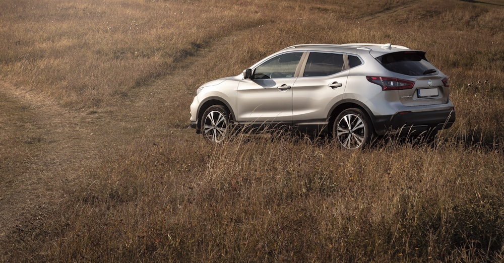 silver sport utility vehicle on grass field