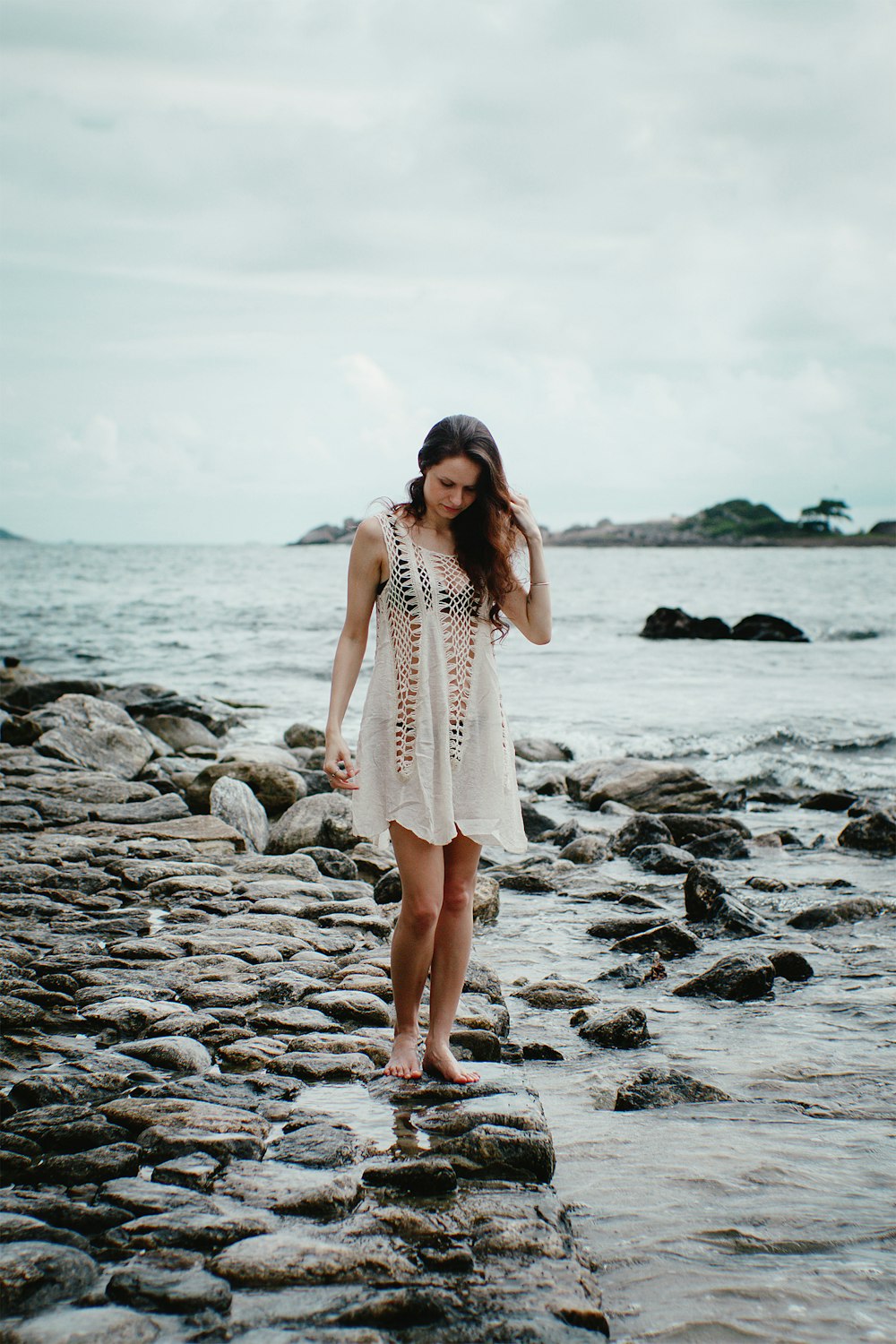 woman wearing white tank dress standing in the beach