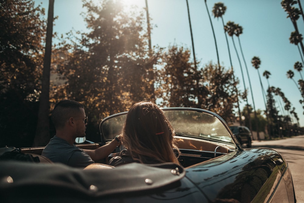 man driving convertible beside woman
