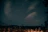 A serene night sky filled with seven glowing stars forming a subtle constellation above a peaceful forest.