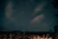 A serene night sky filled with seven glowing stars forming a subtle constellation above a peaceful forest.