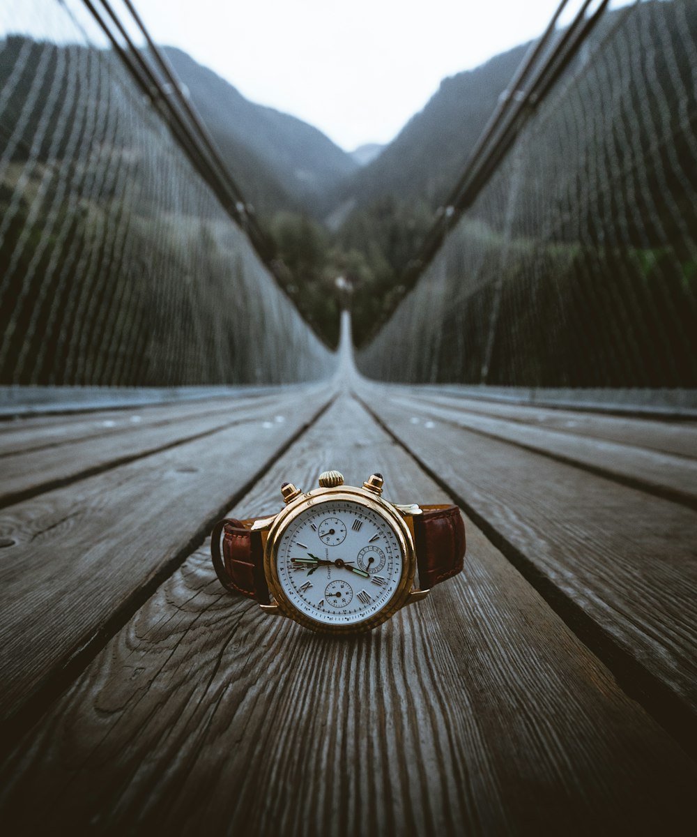 gold-colored chronograph watch with brown leather band