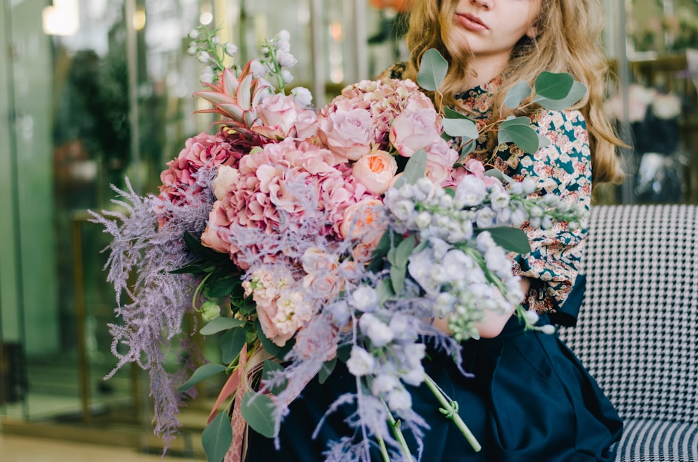 woman holding bundles of pink and white flowers