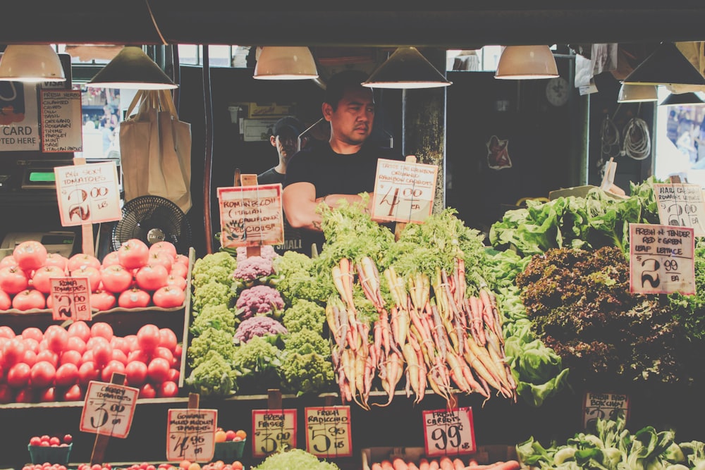 Hombre de pie junto a las verduras