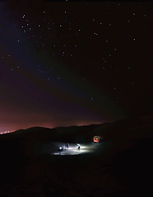 A software startup team brainstorming under an ethereal, star-lit sky.
