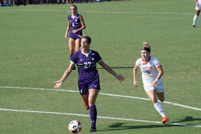 Close-up of a female player dribbling the ball with determination during a match.
